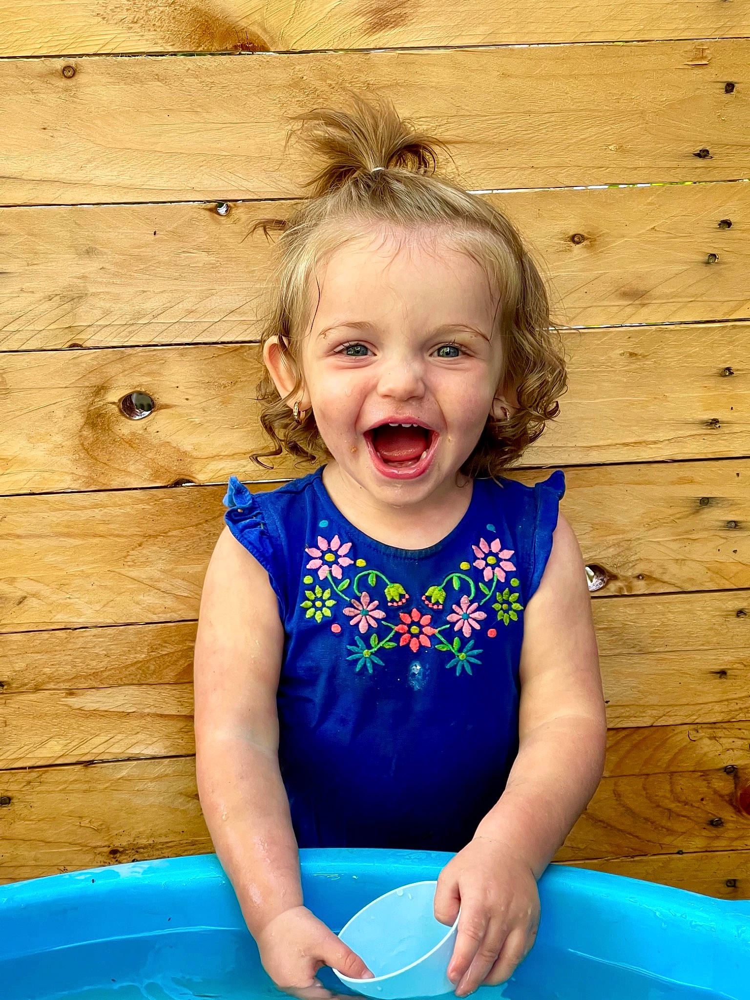 Hadley is registered to the contest to win money with this photo: baby_toddler_clothing, blond, blue, cheek, child, dress, face, facial_expression, fun, happy, leisure, people_in_nature, person, photograph, pink, skin, smile, standing, summer, toddler