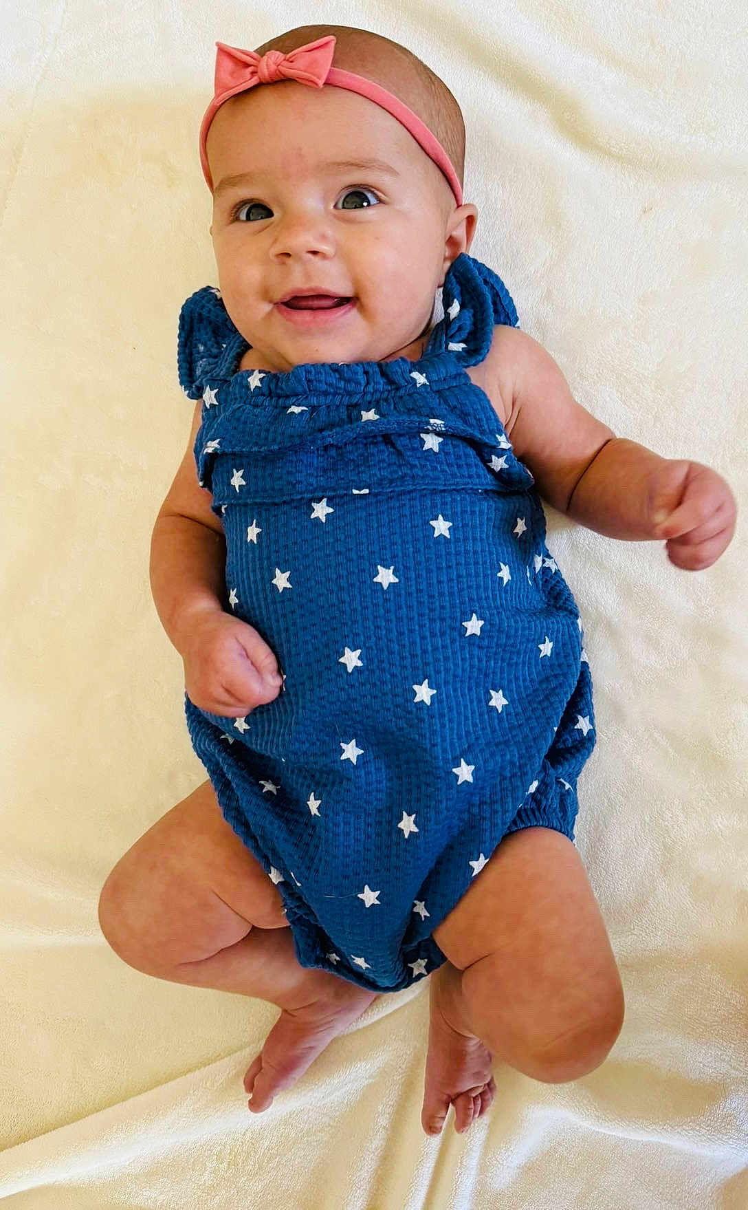 Blakelynn joined the competition — help win amazing prizes! baby, infant, smile, headband, bow, blue_romper, stars, lying_down, blanket, cute, happy, skin, feet, arms, face, child, adorable, soft_texture, newborn, portrait
