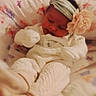 Trishlynn is registered to the contest to win money with this photo: baby, infant, headband, flower, white_outfit, blanket, patterned_blanket, sleeping, cozy, soft_lighting, indoor, cute, child, portrait, warm_colors, baby_clothes, lying_down, small_face, newborn, mood_text