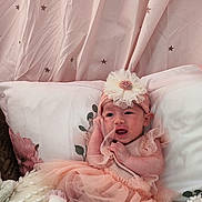 Angelina joined the competition — help win amazing prizes! baby, infant, tutu, headband, flower, pink, curtain, stars, pillow, blanket, bed, soft_texture, cute, child, sitting, smiling, indoors, clothing, portrait, cozy