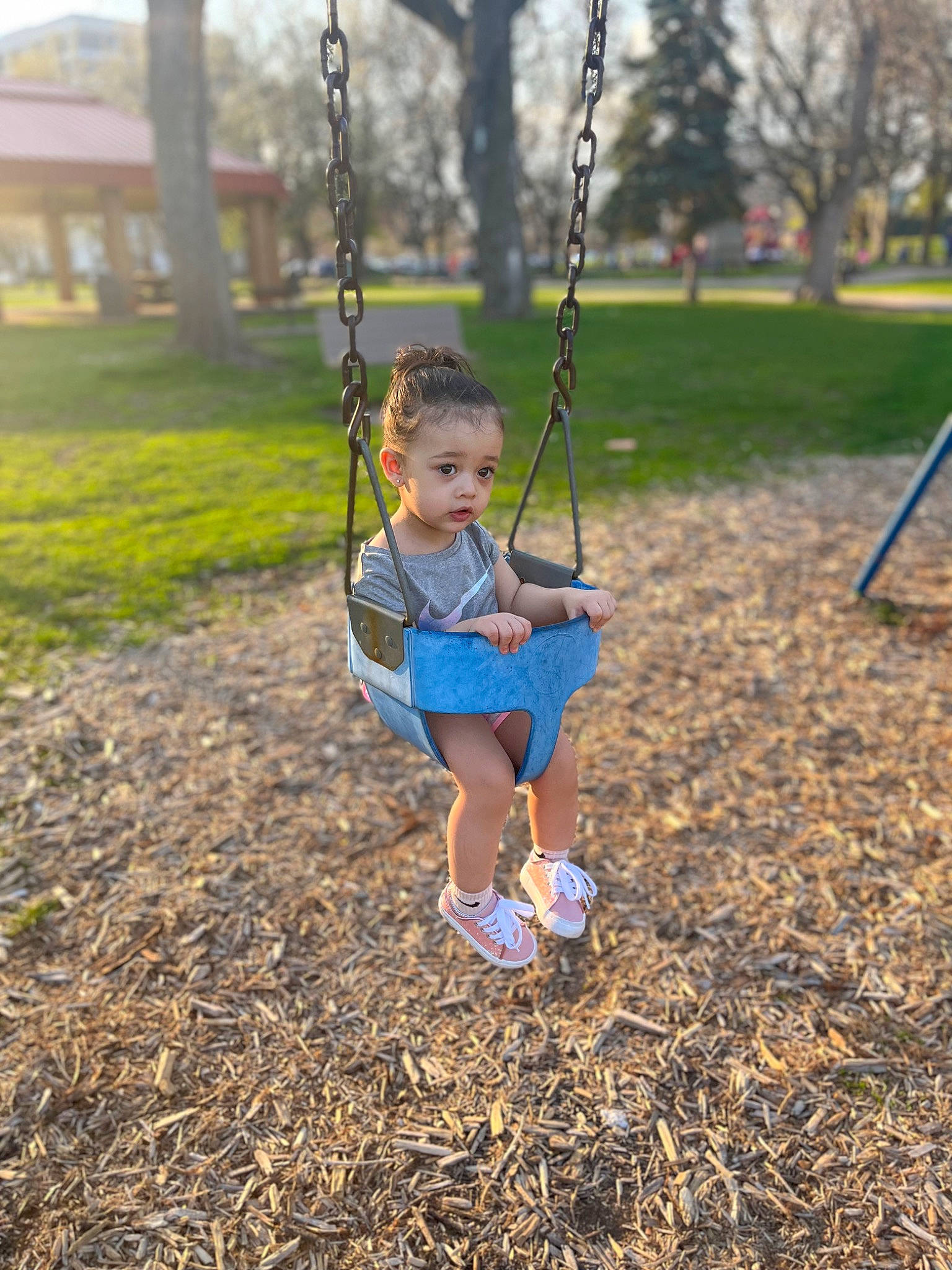 Samaya is registered to the contest to win money with this photo: baby, baby_toddler_clothing, child, city, electric_blue, fun, grass, happy, leisure, outdoor_play_equipment, people_in_nature, person, plant, play, playground, recreation, soil, swing, toddler, tree