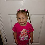 Krysta joined the competition — help win amazing prizes! child, girl, smiling, pink_clothing, braided_hair, pigtails, indoor, door, carpet, standing, cute, portrait, young_child, casual_wear, happy, fashion, person, hair_accessory, graphic_tshirt, toddler