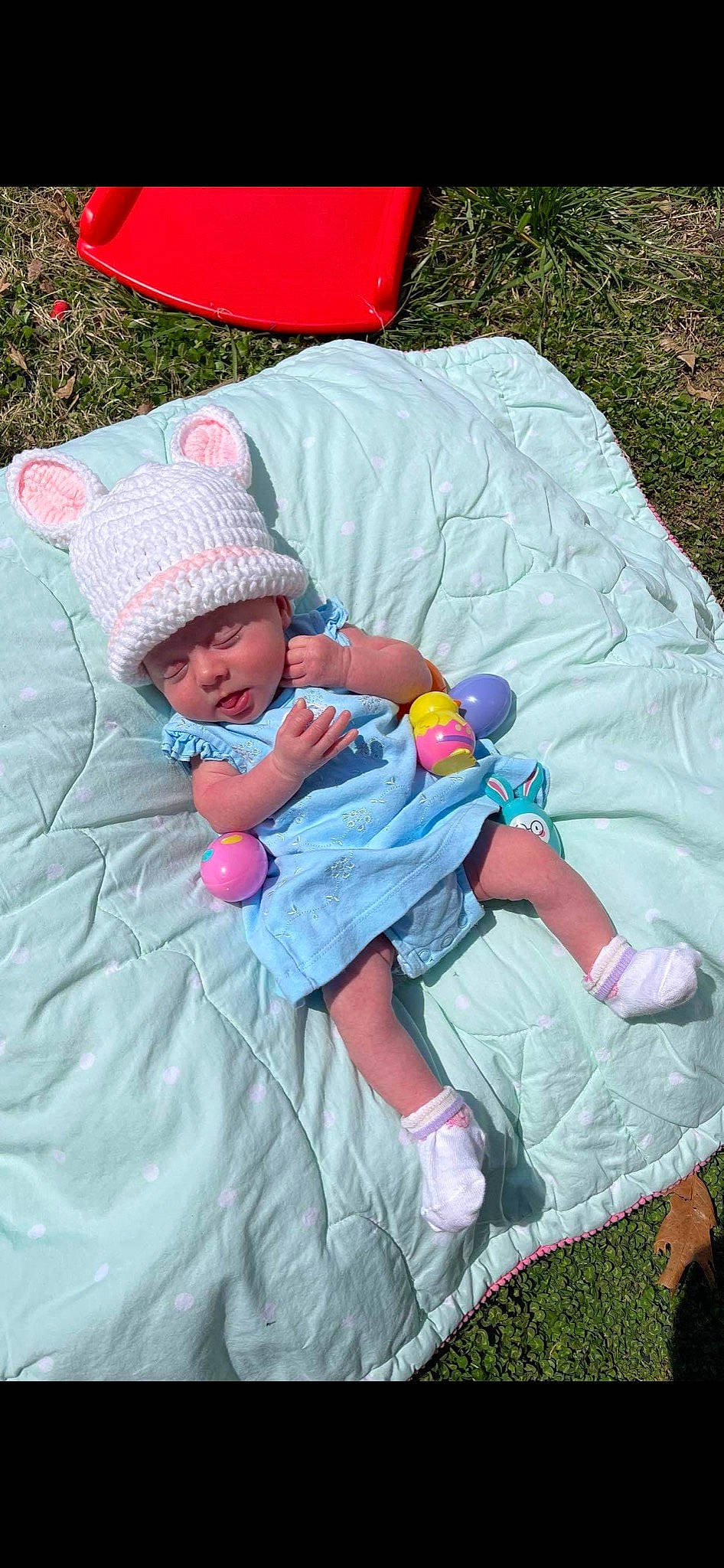 Emma is registered to the contest to win money with this photo: baby, baby_products, baby_toddler_clothing, cap, child, comfort, fun, grass, headwear, lap, leaf, leisure, linens, magenta, person, pink, product, recreation, sitting, textile