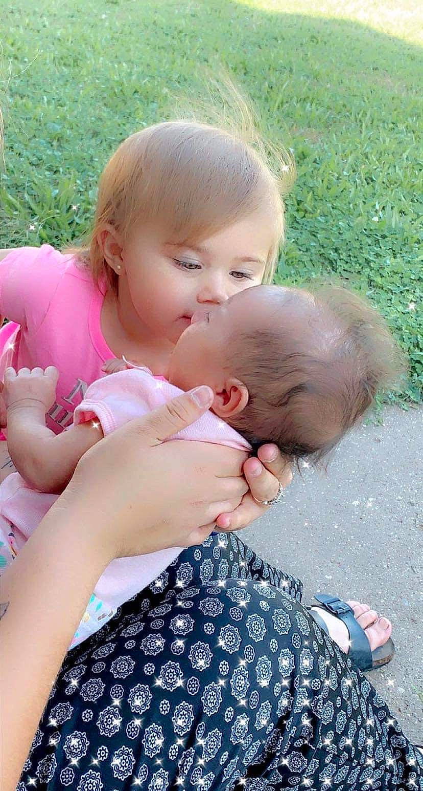 Harmoni is registered to the contest to win money with this photo: baby, baby_toddler_clothing, child, dress, finger, fun, gesture, grass, grass_family, hairstyle, hand, happy, nail, pattern, people_in_nature, person, pink, plant, skin, thumb