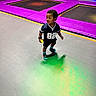 child, kid, trampoline_park, indoor, colorful, sporty_clothing, socks, toy, playing, curious, floor, purple_padding, active, young, person, fun, recreation, leisure, casual, footwear