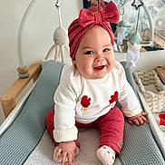 Willow a rejoint le concours — aidez-le/la à gagner de superbes lots ! baby, smiling, headband, pink, changing_mat, mirror, reflection, toy, octopus_toy, bird_toy, white_clothing, red_pants, sock, hand, face, indoor, nursery, person, photography, happy