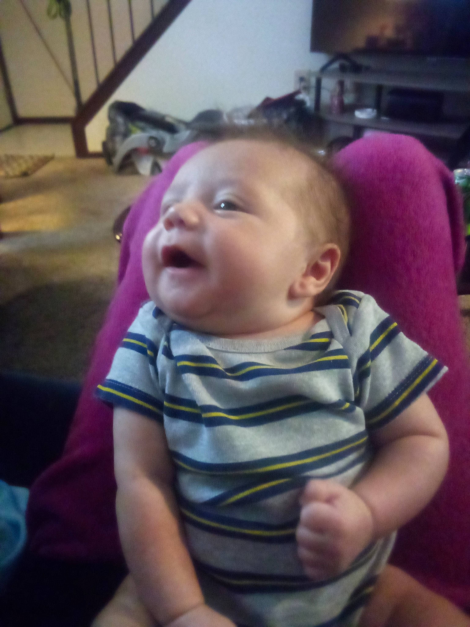 Kevin is registered to the contest to win money with this photo: baby, baby_toddler_clothing, cheek, child, comfort, ear, flooring, fun, happy, iris, mouth, nose, person, purple, room, sitting, skin, smile, t_shirt, television