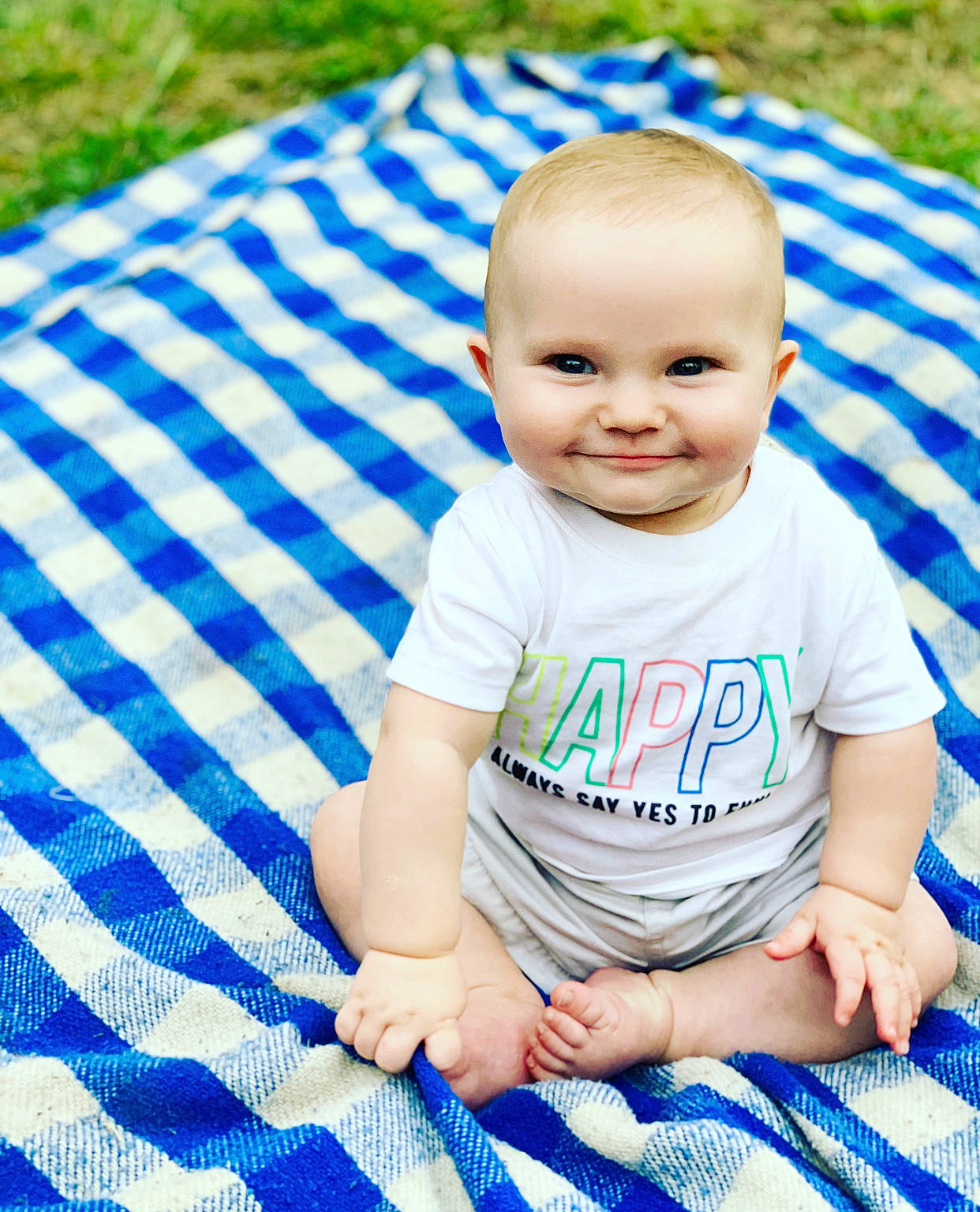 Richie is registered to the contest to win money with this photo: baby, baby_products, baby_toddler_clothing, child, grass, joy, pattern, person, plaid, product, recreation, summer, toddler, tummy_time