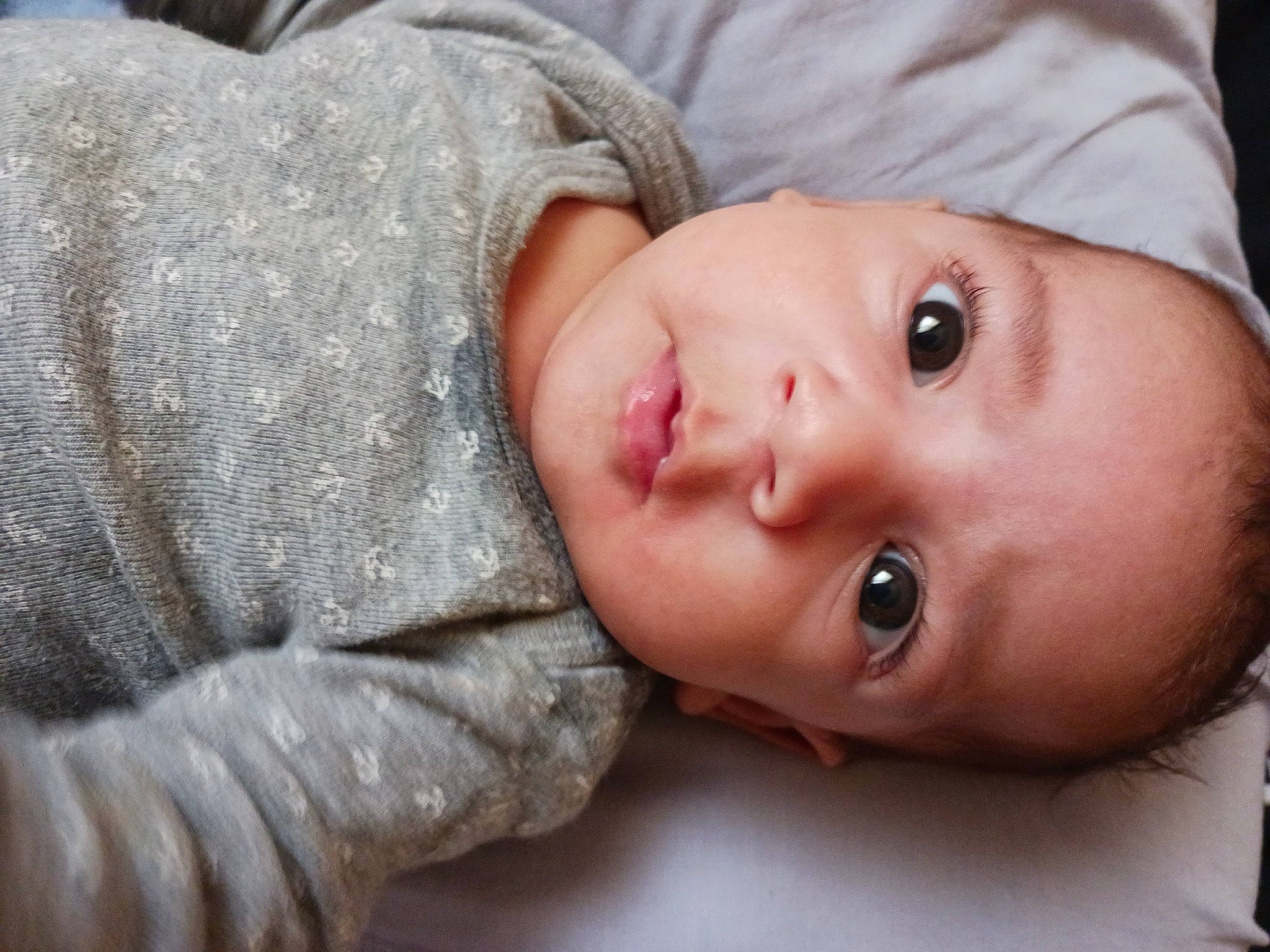 Jakobi is registered to the contest to win money with this photo: baby, baby_toddler_clothing, cheek, chin, comfort, eyebrow, eyelash, flash_photography, grass, headgear, human_body, iris, lip, mammal, mouth, neck, nose, person, skin, textile