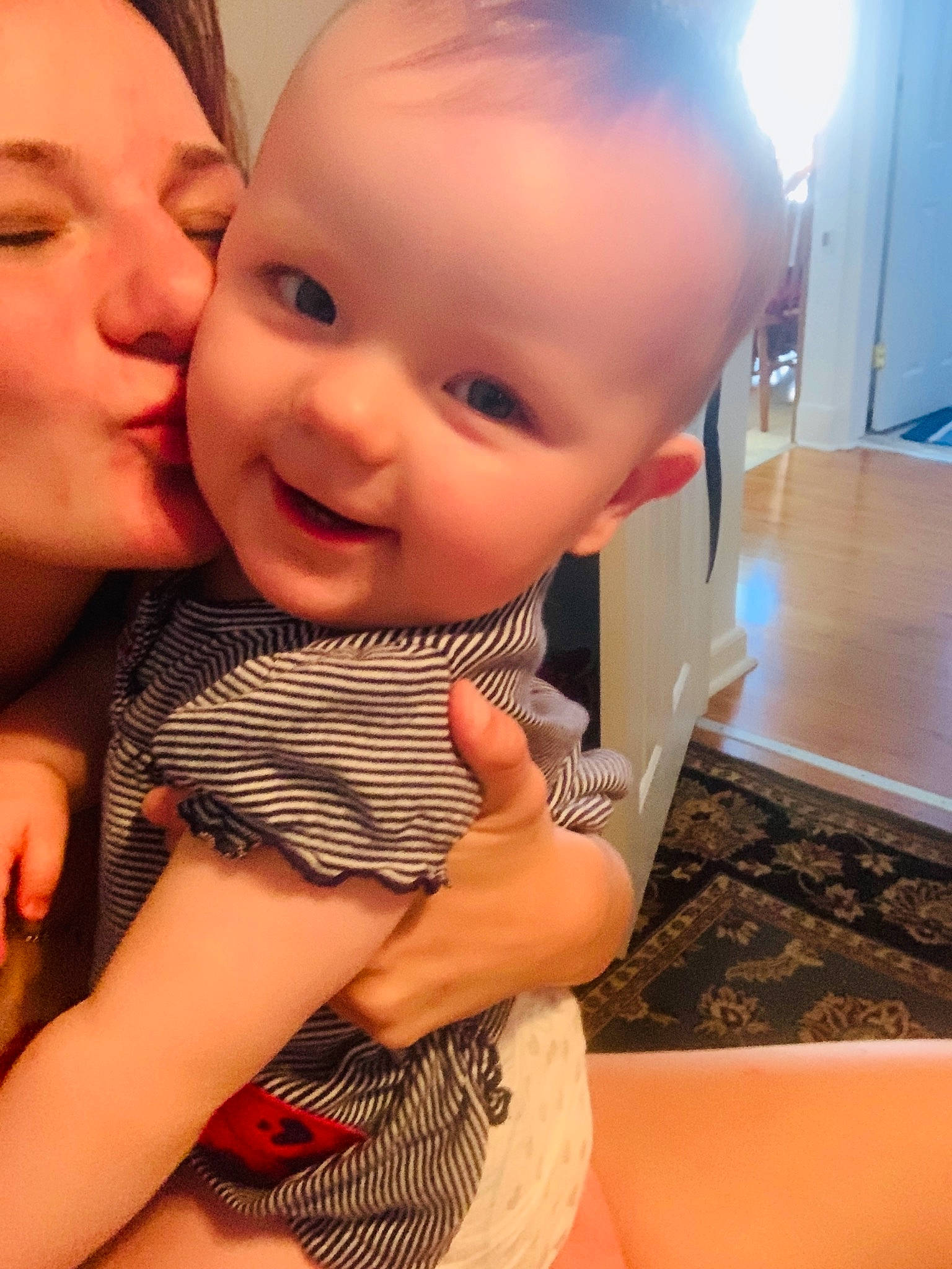 Alaska is registered to the contest to win money with this photo: baby, cheek, child, daughter, electronic_device, face, finger, forehead, happy, head, interaction, leg, lip, mother, nose, person, skin, smile, thumb, toddler