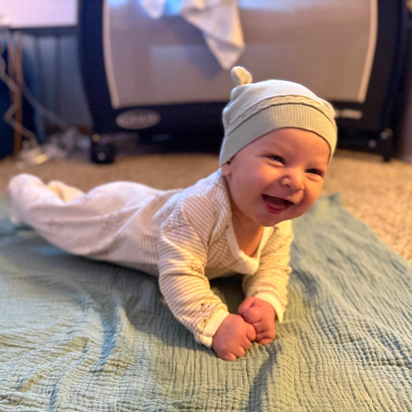 Caruso joined the competition — help win amazing prizes! baby, blanket, carpet, child, cozy, cute, floor, happy, hat, home, indoor, infant, pajamas, person, playpen, portrait, smiling, soft_lighting, tummy_time, young_child