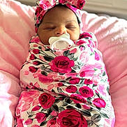 Nyjah joined the competition — help win amazing prizes! newborn, baby, sleeping, pacifier, swaddled, floral, rose_pattern, headband, bow, portrait, infant, face, indoors, blanket, pink, red, peaceful, nursery, close_up, photography