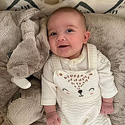 Lise participe au concours pour gagner de l'argent avec cette photo : baby, infant, smile, face, clothing, onesie, plush, elephant, pillow, crib, bed, soft, cute, child, person, happy, indoors, laying, cozy, white