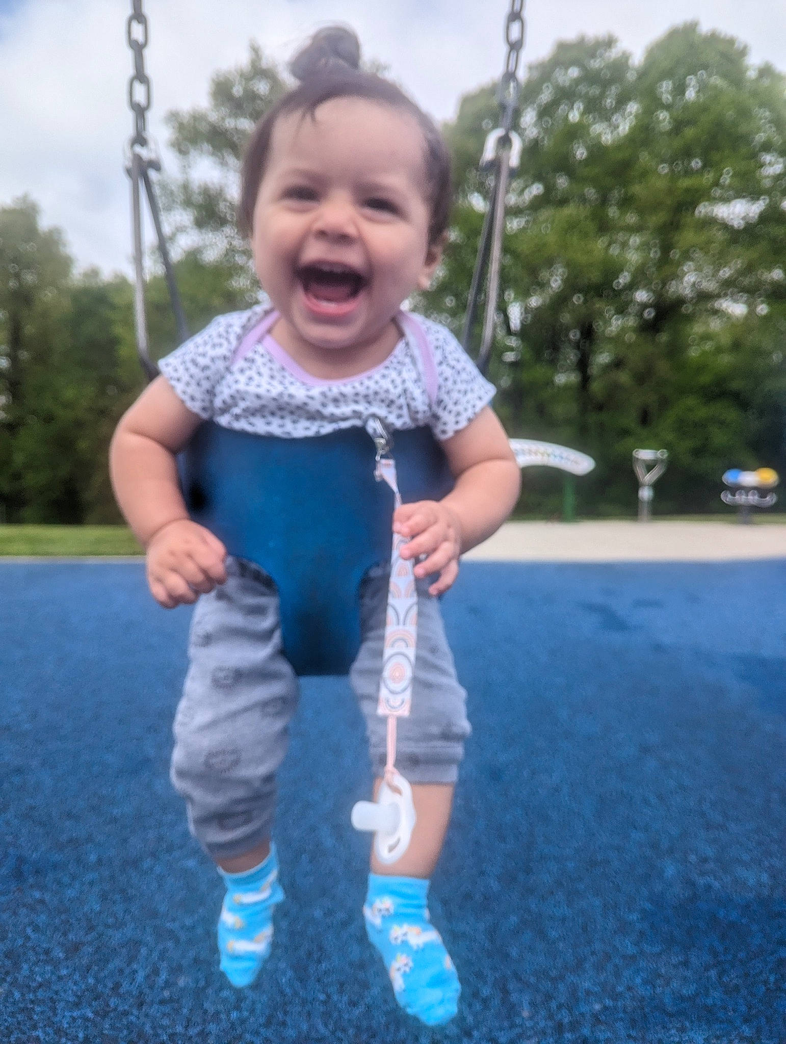 Sophie is registered to the contest to win money with this photo: azure, baby_toddler_clothing, electric_blue, finger, fun, gesture, grass, hand, happy, leisure, person, product, recreation, sky, sleeve, smile, standing, swing, t_shirt, toddler
