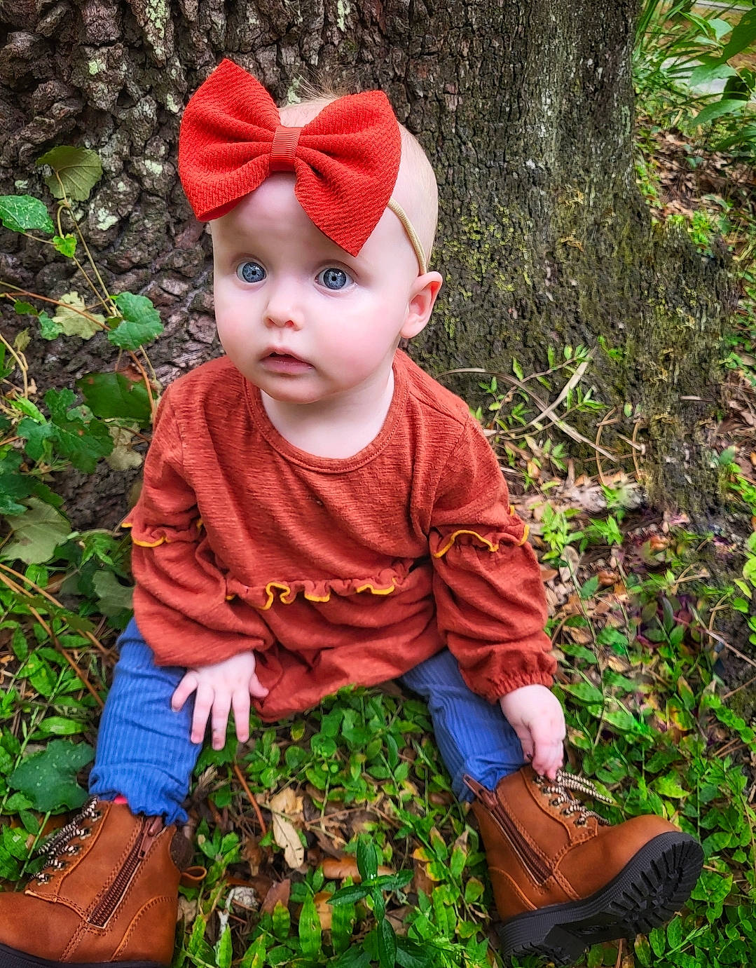 Riley joined the competition — help win amazing prizes! baby, baby_toddler_clothing, beanie, cap, child, fashion_accessory, fur, garden, grass, headwear, leaf, magenta, pattern, people_in_nature, person, plant, portrait_photography, sitting, sleeve, surprise