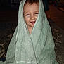 toddler, child, towel, smile, indoors, face, bath_time, happy, wrapped, cute, carpet, toy, living_room, hair, skin, person, blanket, fun, cozy, home