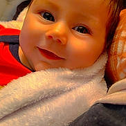 Paisley joined the competition — help win amazing prizes! baby, infant, smile, face, blanket, closeup, child, cute, happy, soft, warm, portrait, toddler, clothing, skin, hair, indoors, person, young, cozy