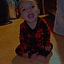 toddler, child, plaid_pajamas, sitting, wooden_floor, indoors, mouth_open, happy, person, barefoot, bed, blanket, mirror, furniture, shadow, room, clothing, floor, smile, cute