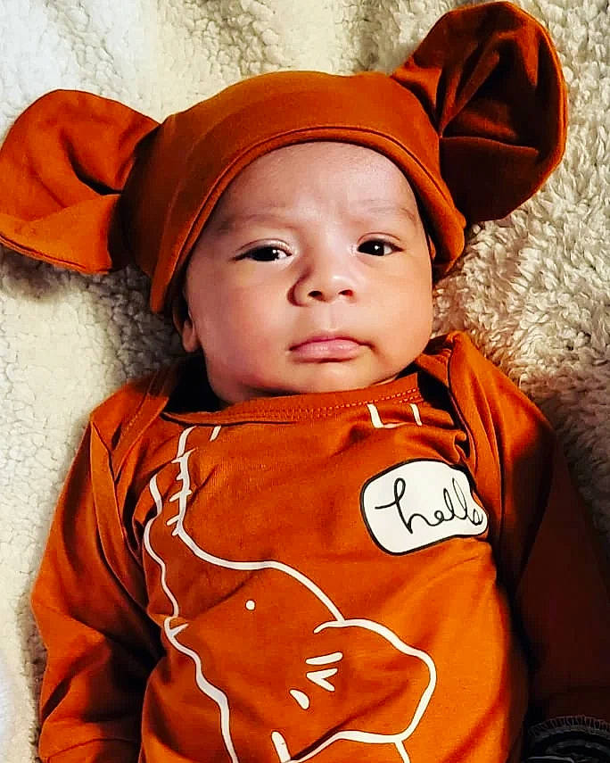 Darien is registered to the contest to win money with this photo: baby, baby_toddler_clothing, cap, cheek, child, costume_accessory, costume_hat, fashion_accessory, fun, happy, hat, head, headwear, human_body, lip, orange, organ, outerwear, peach, person