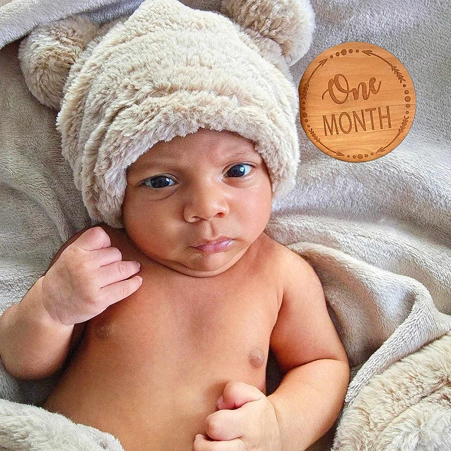 Dashiell is registered to the contest to win money with this photo: newborn, baby, infant, portrait, face, eyes, hat, bear_hat, blanket, fluffy, cozy, milestone, one_month, wooden_sign, indoor, lying_down, bare_chest, hand, cute, photography