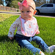 Lillian joined the competition — help win amazing prizes! baby, infant, child, headband, bow, bib, jeans, socks, grass, outdoors, sunlight, portrait, sitting, expression, cute, lawn, trees, fence, vehicle, daytime