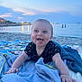 Roméo participe au concours pour gagner de l'argent avec cette photo : baby, beach, towel, sand, water, sea, sunset, child, smile, tongue, playful, outdoor, sky, horizon, people, vacation, relaxation, clothing, blanket, happy