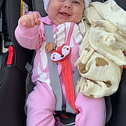 Elyana participe au concours pour gagner de l'argent avec cette photo : baby, infant, car_seat, pink_clothing, white_hat, pom_poms, blanket, toy, fox_toy, smiling, happy, face, child, sitting, safety_harness, white_socks, cute, cozy, indoors, portrait