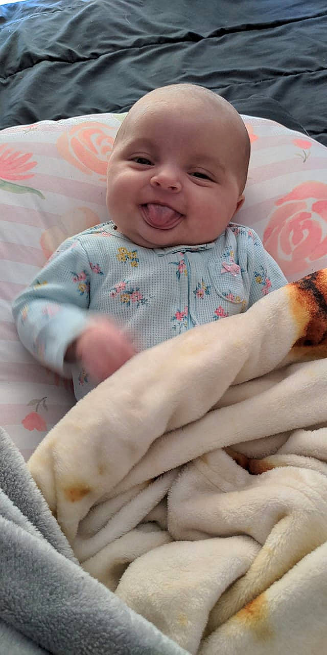 Phoebe is registered to the contest to win money with this photo: baby, baby_toddler_clothing, cheek, child, comfort, eye, facial_expression, finger, gesture, hand, happy, mouth, people, person, pink, skin, sleeve, smile, textile, toddler