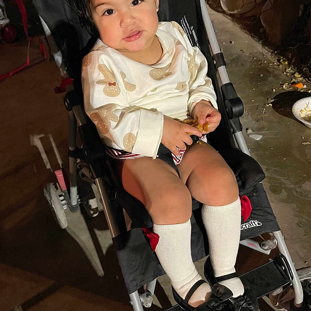 Devani is registered to the contest to win money with this photo: child, clothing, face, female, footwear, furniture, girl, happy, head, hosiery, machine, person, photography, portrait, shoe, sitting, smile, sock, stroller, wheel