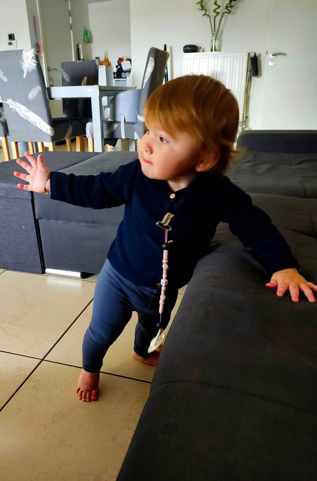 Gaïa participe au concours pour gagner de l'argent avec cette photo : baby_toddler_clothing, balance, child, floor, flooring, fun, hardwood, houseplant, human_leg, joint, knee, person, picture_frame, plant, room, sitting, sleeve, standing, toddler, wood