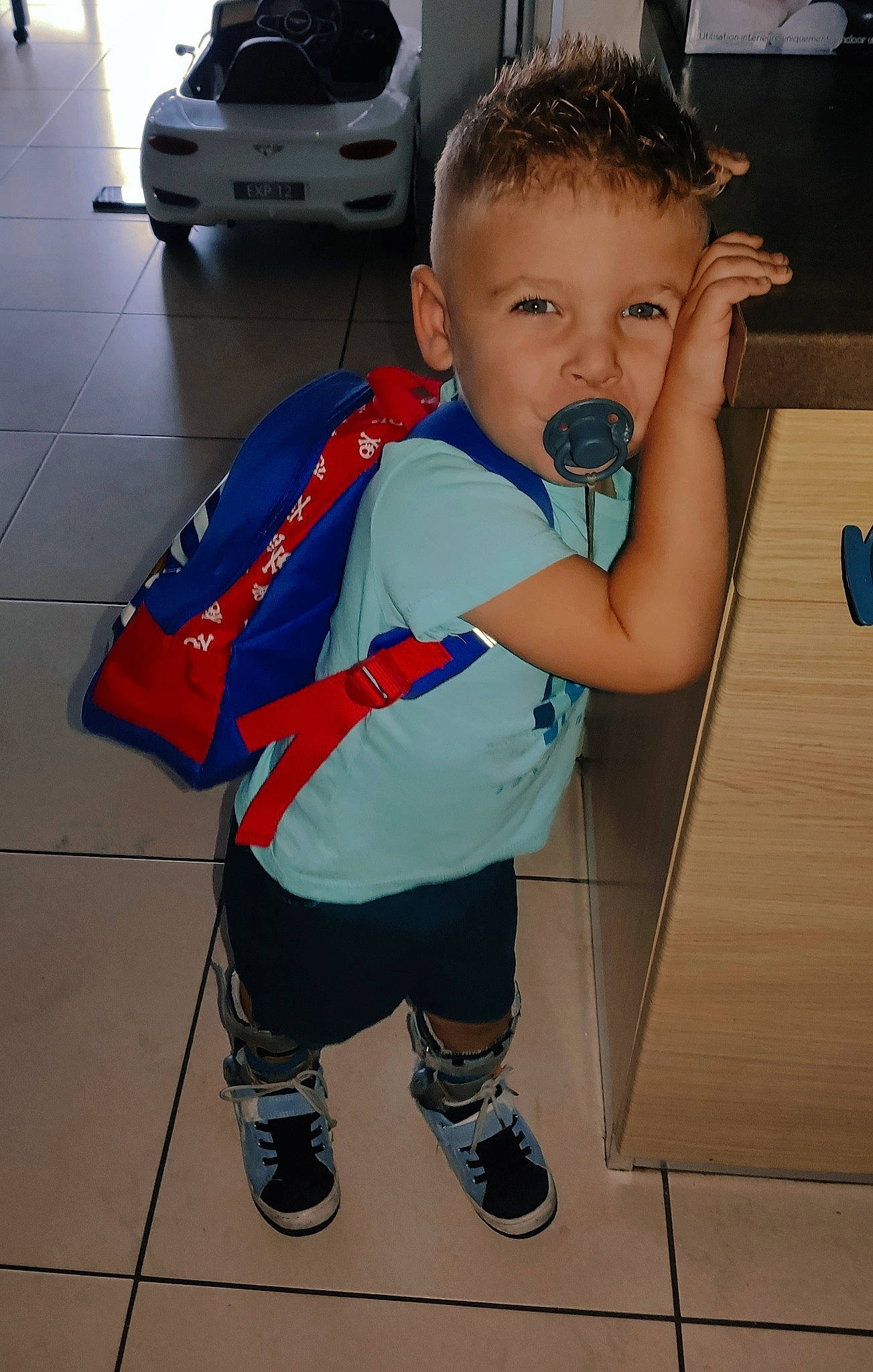 Attilio a rejoint le concours — aidez-le/la à gagner de superbes lots ! automotive_design, automotive_exterior, automotive_lighting, automotive_tire, baby_toddler_clothing, car, flooring, head, hood, leg, person, shoe, shorts, sneakers, t_shirt, thigh, tire, toddler, vehicle, vehicle_door