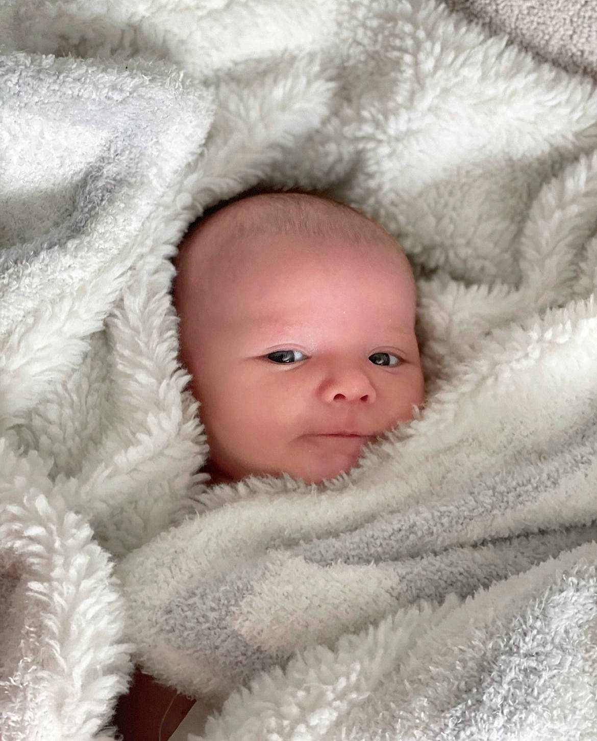 Graham is registered to the contest to win money with this photo: baby, beauty, cheek, comfort, eye, eyelash, face, flash_photography, freezing, fur, fur_clothing, grey, happy, head, iris, linens, nose, person, textile, toddler