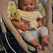 Tobias joined the competition — help win amazing prizes! baby, infant, smile, plush_toy, baby_rocker, cushion, child, happy, indoor, person, face, clothing, toy, cute, feet, sitting, comfort, relaxation, young, small