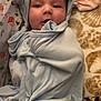 Makai is registered to the contest to win money with this photo: baby, child, blanket, blue, hood, ears, soft, cute, face, indoor, wrapped, cozy, pattern, fabric, animal_print, infant, portrait, smiling, clothing, young
