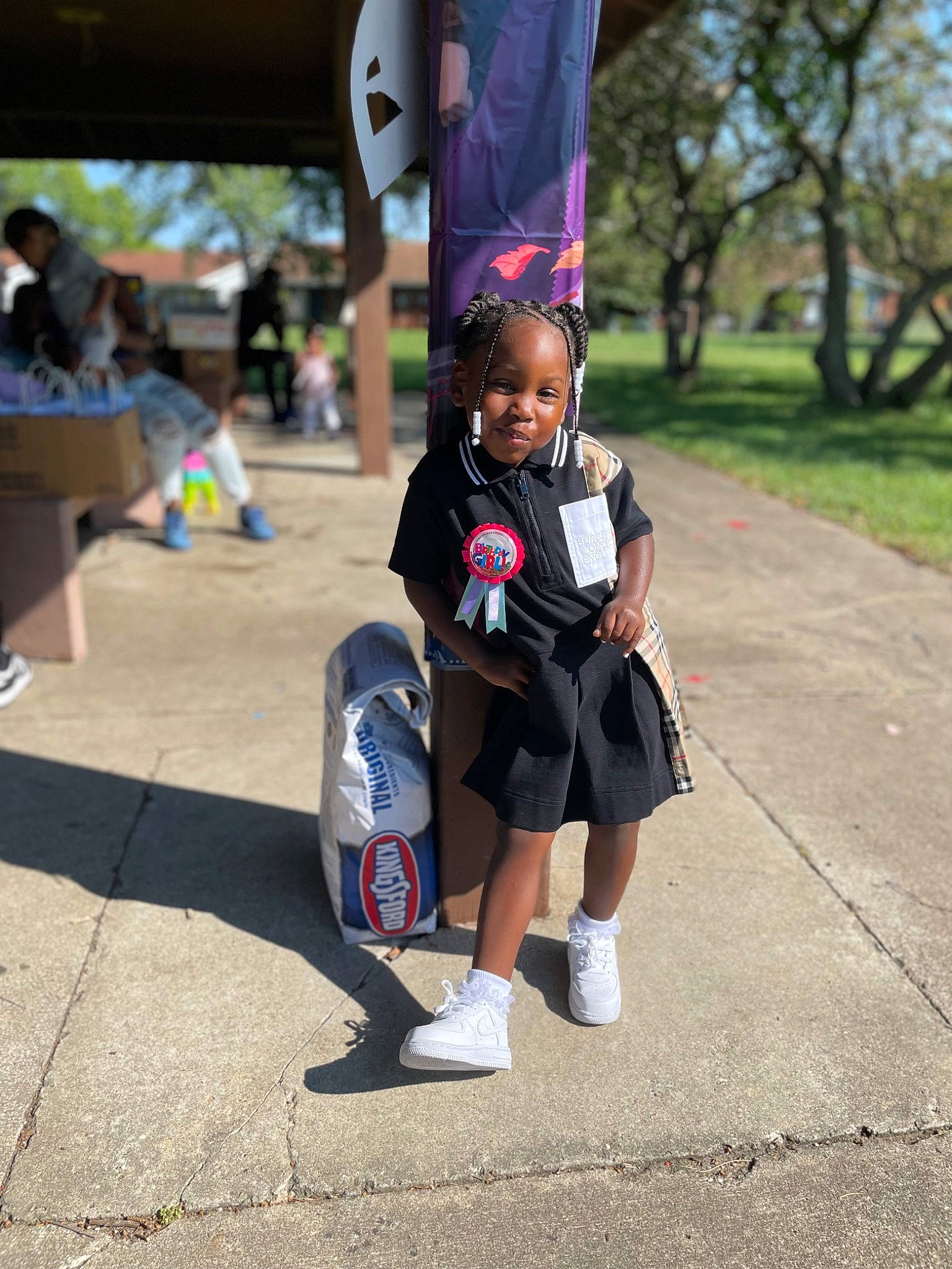 Marianna is registered to the contest to win money with this photo: asphalt, child, electric_blue, event, eyewear, flag, fun, human_leg, knee, leisure, pedestrian, person, personal_protective_equipment, recreation, road, shorts, street, t_shirt, thigh, toddler