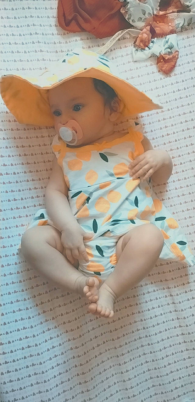 Dalilah joined the competition — help win amazing prizes! baby, baby_toddler_clothing, baby_toys, child, doll, dress, fashion_accessory, fawn, foot, hat, human_leg, pattern, peach, person, sitting, skin, sleeve, stuffed_toy, thigh, toddler