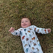 Jerrold joined the competition — help win amazing prizes! baby, child, grass, outdoor, onesie, animal_print, smiling, happy, infant, lying_down, nature, cute, clothing, young_child, playful, casual, daylight, person, portrait, joyful
