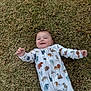 baby, child, grass, outdoor, onesie, animal_print, smiling, happy, infant, lying_down, nature, cute, clothing, young_child, playful, casual, daylight, person, portrait, joyful