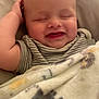Grayson is registered to the contest to win money with this photo: baby, smiling, blanket, striped_clothing, happy, infant, face, sleepy, cute, child, cozy, soft, cheerful, resting, portrait, toddler, relaxed, indoors, skin, head