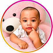 Yusuf joined the competition — help win amazing prizes! baby, child, teddy_bear, pink, cute, portrait, indoor, soft_toy, hand, face, young, childhood, smiling, looking_at_camera, clothing, infant, circular_frame, furniture, plush, expression