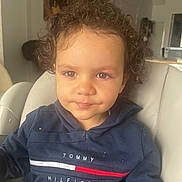 Khalis participe au concours pour gagner de l'argent avec cette photo : baby, blue_hoodie, casual_wear, child, clothing, comfortable, curly_hair, cute, expression, face, home, indoor, natural_light, person, portrait, seated, smile, toddler, white_chair, young_child