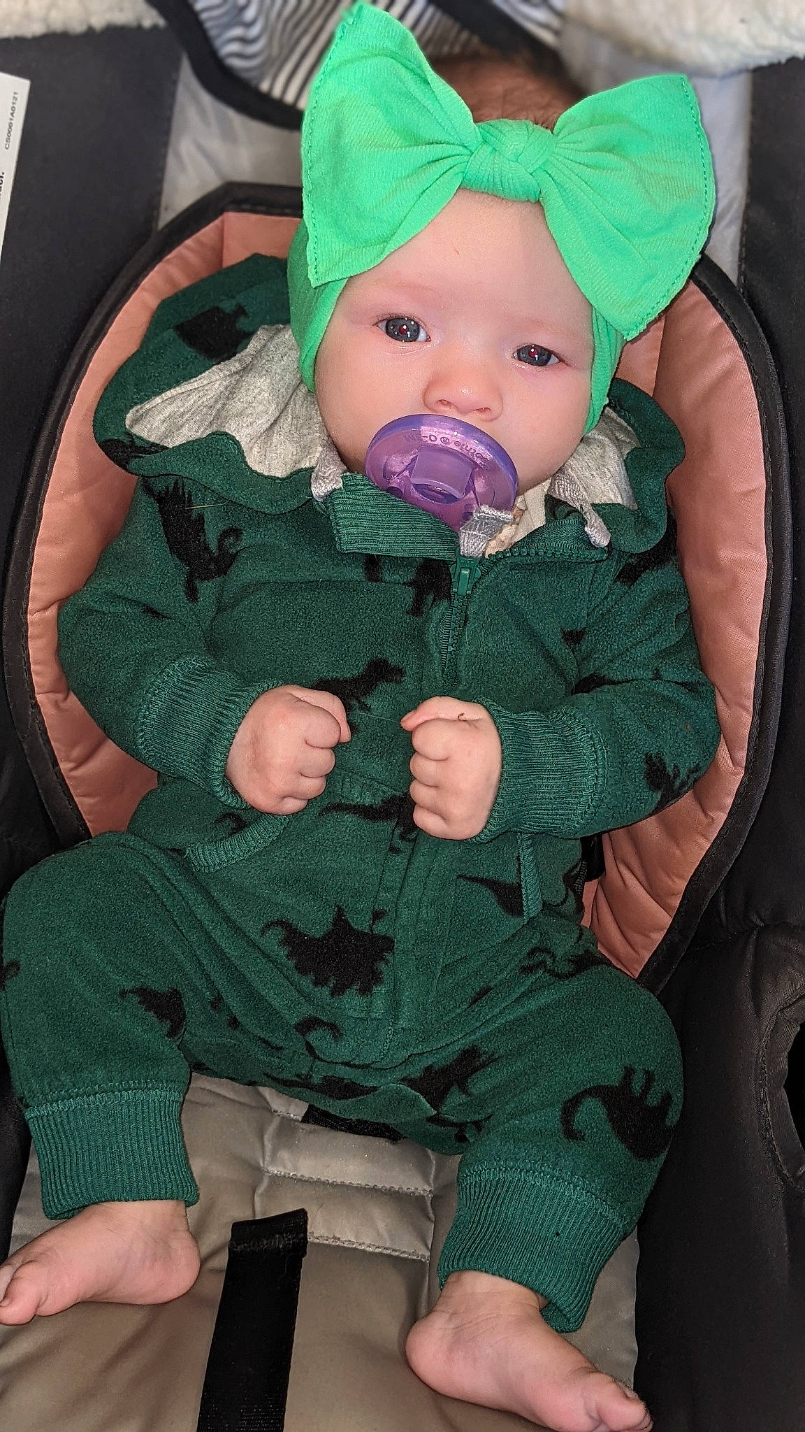 Paislynn is registered to the contest to win money with this photo: baby, baby_products, baby_safety, baby_toddler_clothing, beanie, chair, cheek, child, comfort, face, green, head, headwear, lap, linens, pattern, person, sitting, sleeve, sock