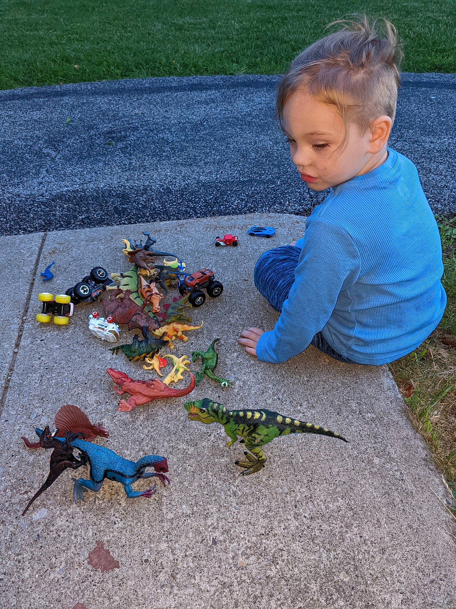 Christian is registered to the contest to win money with this photo: art, asphalt, blue, carmine, child, concrete, electric_blue, fictional_character, flooring, fun, grass, leisure, person, plastic, play, road_surface, sidewalk, sitting, toddler, toy