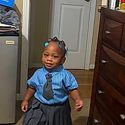 Taliyah joined the competition — help win amazing prizes! child, toddler, girl, school_uniform, striped_shirt, tie, pleated_skirt, sneakers, white_socks, hair_beads, blue_accessories, standing, smiling, indoors, bedroom, door, dresser, carpet, mini_fridge, portrait