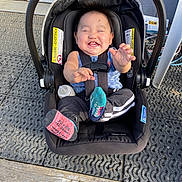 Elwood Liam Brown is registered to the contest to win money with this photo: baby, car_seat, child, smiling, happy, socks, bottle, outdoor, seatbelt, black, clothing, person, infant, floor, door, plastic, metal, texture, babywear, playful
