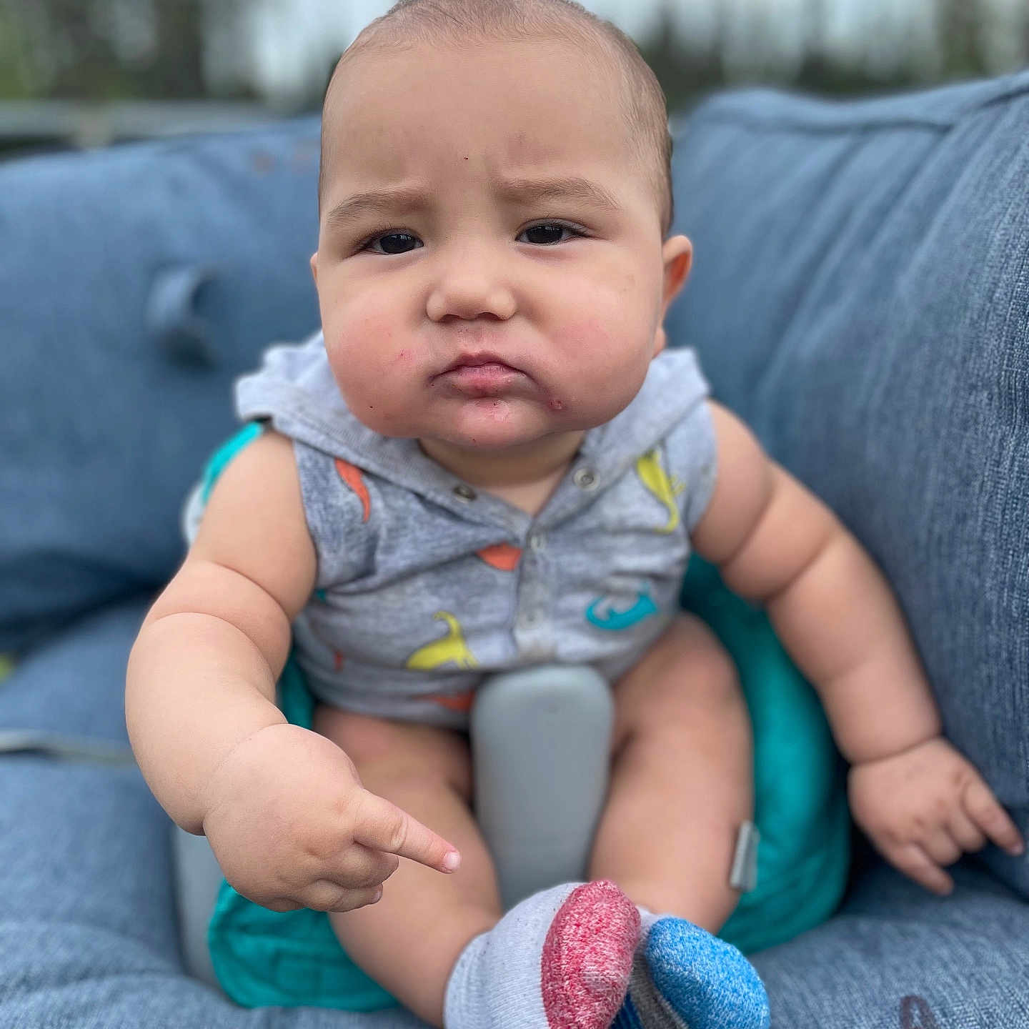 Caleb Ray joined the competition — help win amazing prizes! baby, blue_sock, child, closeup, clothing, cushion, face, hand, infant, legs, mismatched_socks, outdoor, person, pointing, portrait, red_sock, serious_expression, sitting, skin, sleeveless_hoodie