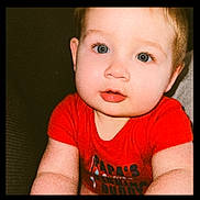 Greyson is registered to the contest to win money with this photo: baby, child, face, blue_eyes, red_shirt, cute, portrait, infant, chubby_cheeks, skin, person, young, sitting, indoors, expression, looking_at_camera, closeup, adorable, human, toddler