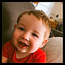 Greyson is registered to the contest to win money with this photo: baby, child, smiling, red_shirt, couch, indoor, face, happy, portrait, young_child, cozy, home, person, closeup, cute, infant, relaxing, soft_lighting, head, skin