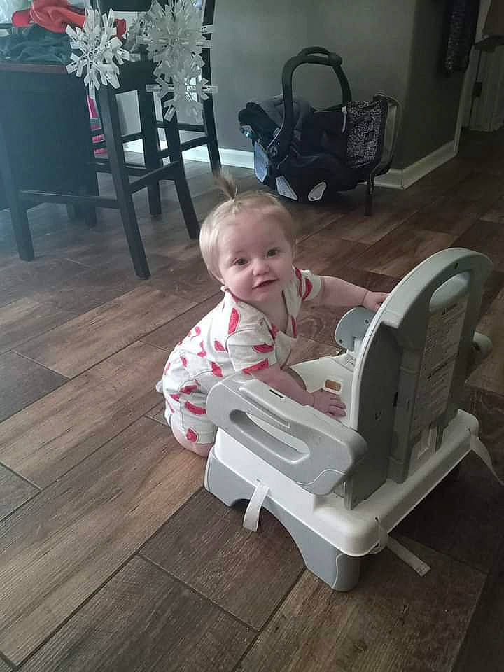 Haisley is registered to the contest to win money with this photo: baby, baby_products, baby_safety, baby_toddler_clothing, black, chair, child, comfort, event, floor, flooring, hardwood, laminate_flooring, lap, person, room, sitting, toddler, varnish, wood