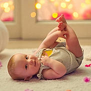 Aurora is registered to the contest to win money with this photo: baby, infant, carpet, floor, playful, smile, feet, clothing, indoor, cute, child, soft_lighting, bokeh, petals, relaxing, portrait, young, happy, toddler, skin
